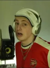 se ve a un joven frente a un micrófono