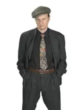 se ve la imagen de un hombre con boina, traje, corbata y pantalon